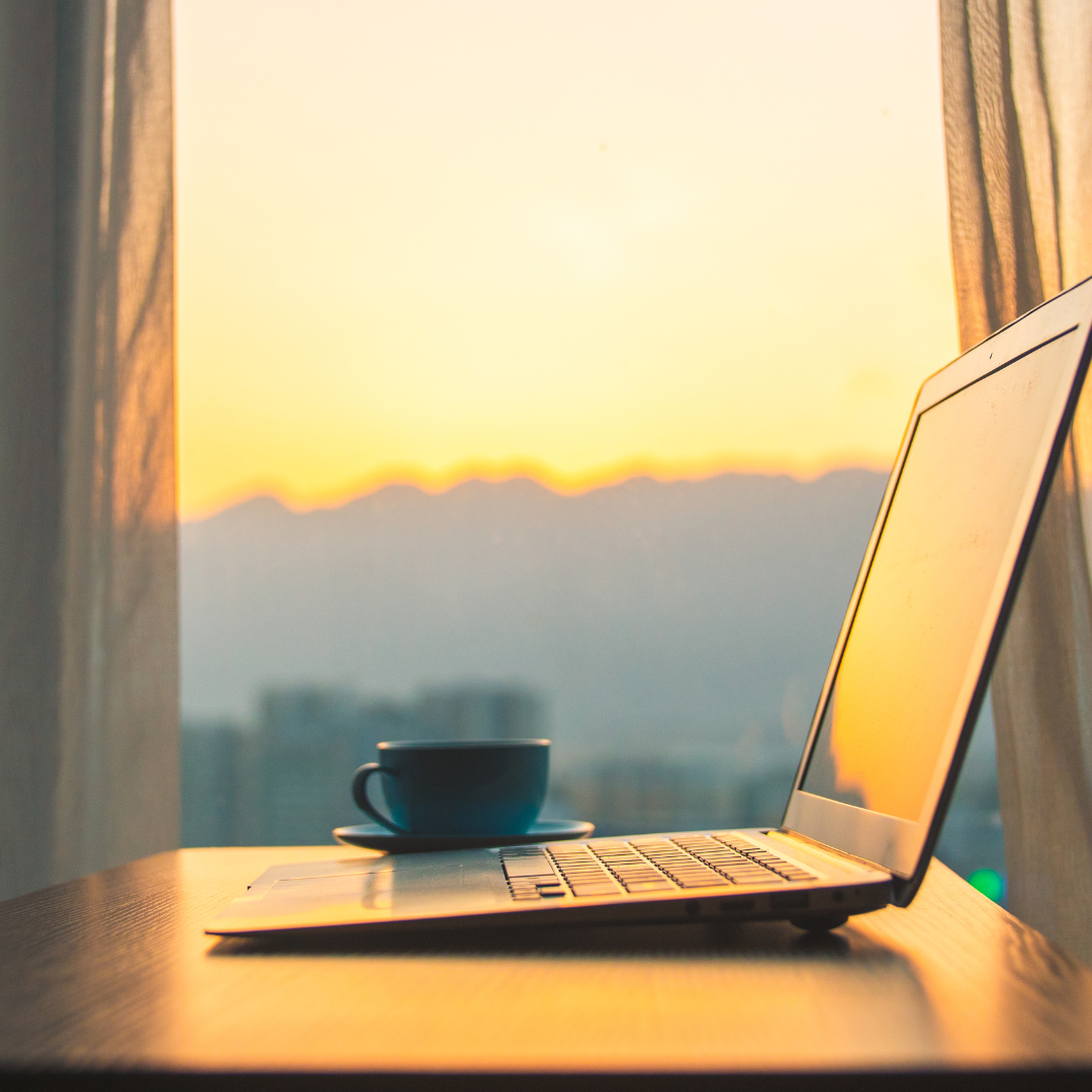 laptop on desk during sunrise